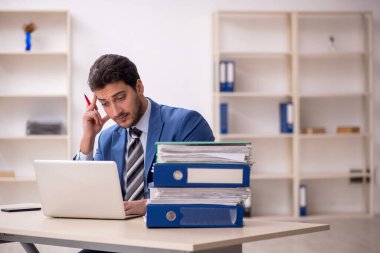 Genç işadamı ve işyerinde çok fazla iş var.