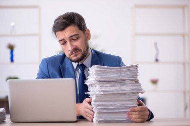 Genç bir çalışan ve ofiste çok fazla iş var.