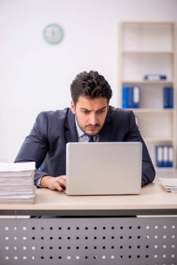 Genç bir çalışan ve ofiste çok fazla iş var.