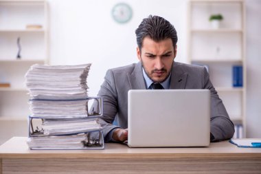 Genç bir çalışan ve ofiste çok fazla iş var.