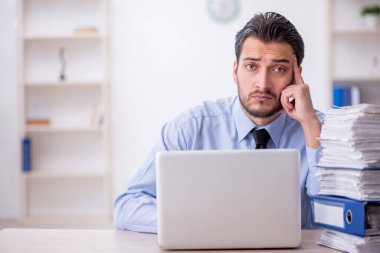 Genç bir çalışan ve ofiste çok fazla iş var.