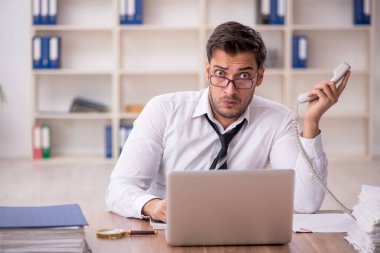 Genç işadamı işyerinde oturuyor.