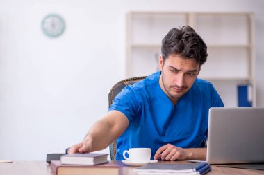 Klinikte kitap okuyan genç bir doktor.