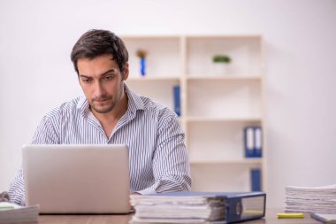 Genç işadamı işyerinde oturuyor.