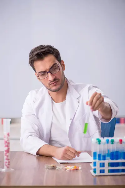 Young chemist in front of white board