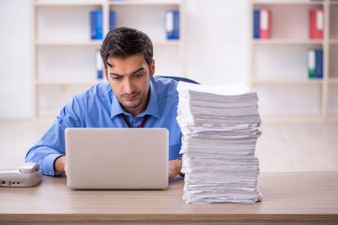 Genç işadamı ve ofiste çok fazla iş var.