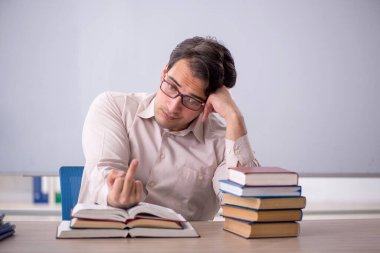 Sınıfta oturan genç öğretmen.