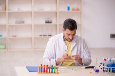 Young chemist sitting at the lab
