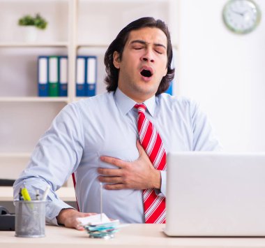 Ofiste acı çeken genç bir erkek işçi.