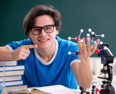 Sınıftaki genç erkek öğrenci.