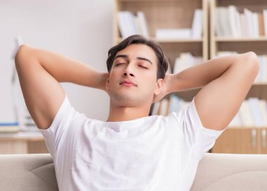 Kanepede dinlenen genç adam.