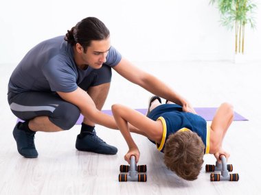 Genç baba ve oğlu egzersiz yapıyor.