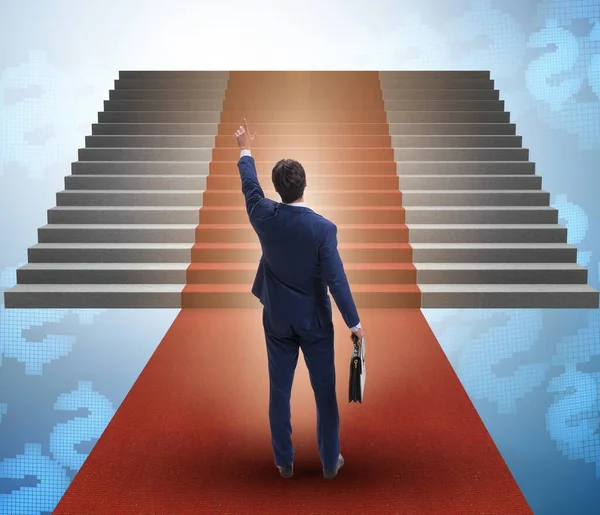 The young businessman climbing stairs and red carpet