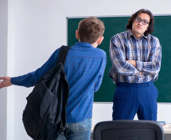 The funny male teacher and boy in the classroom