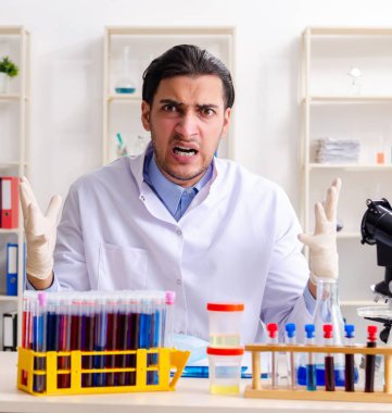 Laboratuvarda çalışan genç erkek kimyager.