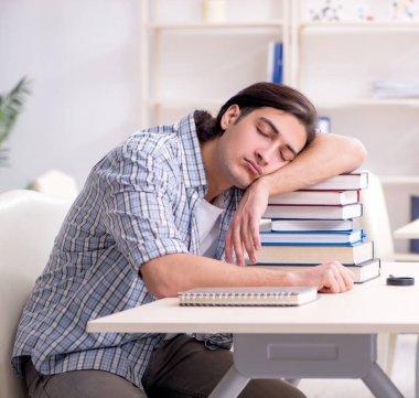 Genç erkek öğrenci evde sınavlara hazırlanıyor.