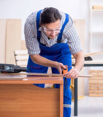 İçeride çalışan genç erkek marangoz.