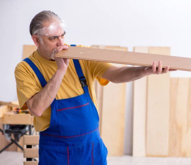 Atölyede çalışan yaşlı erkek marangoz.