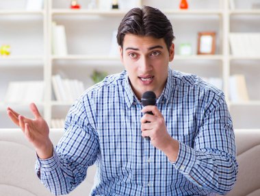 Evde karaoke yapan komik adam.