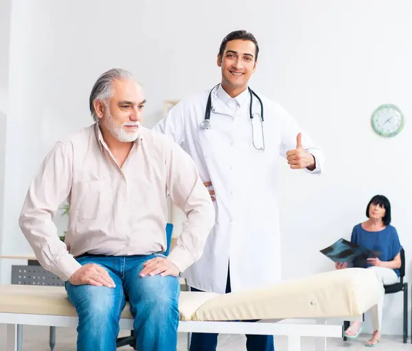 Old Couple Visiting Young Male Doctor — Stock Photo, Image