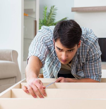 Evde mobilya montajı yapan adam.