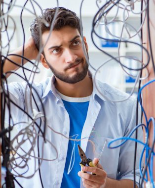 Elektrik teknisyeni tamir konseptinde kabloları çözmeye çalışıyor.