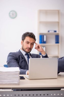 Genç bir çalışan ve ofiste çok fazla iş var.