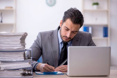 Genç bir çalışan ve ofiste çok fazla iş var.