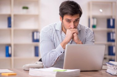 Genç işadamı işyerinde oturuyor.