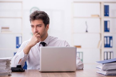 Young employee and too much work at workplace