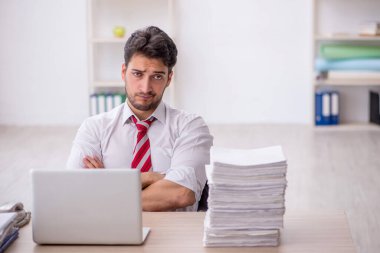 Ofisteki aşırı işten memnun olmayan genç bir çalışan.