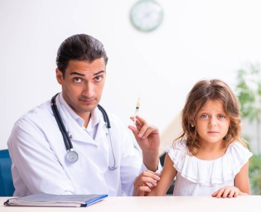 Küçük bir kızla birlikte genç doktor çocuk doktoru.