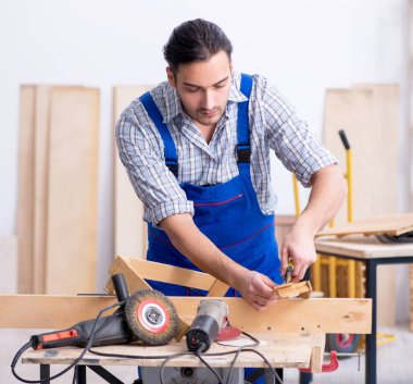 İçeride çalışan genç erkek marangoz.