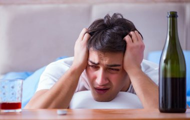 Yatakta içen alkolik adam depresyona giriyor.