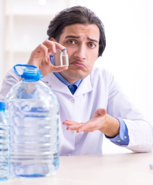 Laboratuvarda deney yapan genç erkek kimyager.