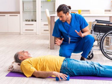 Genç erkek doktor eski hastayı ziyaret ediyor.