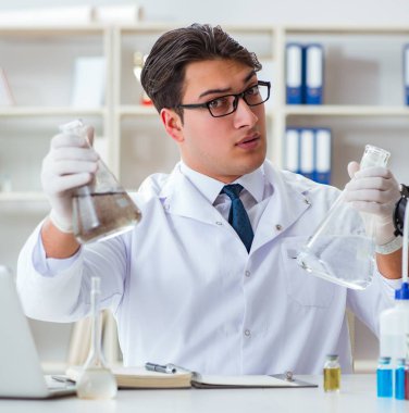 Genç araştırmacı bilim adamı laboratuarda bir su testi kirliliği deneyi yapıyor.