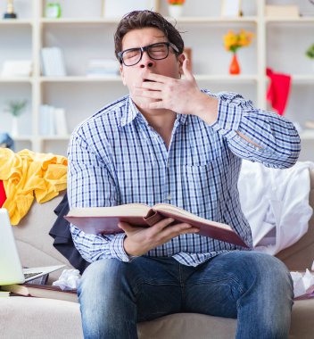 Dağınık odada çalışan genç adam.