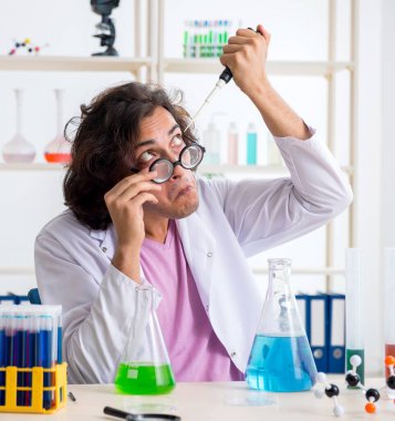 Laboratuvarda çalışan komik erkek kimyager.