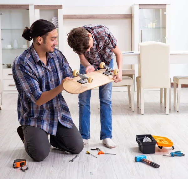 Young Father Repairing Skateboard His Son Home — Stock Photo, Image