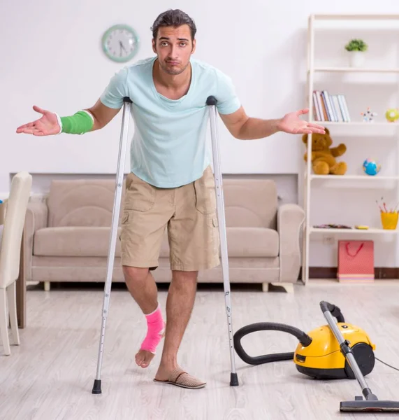 The young injured man cleaning the house