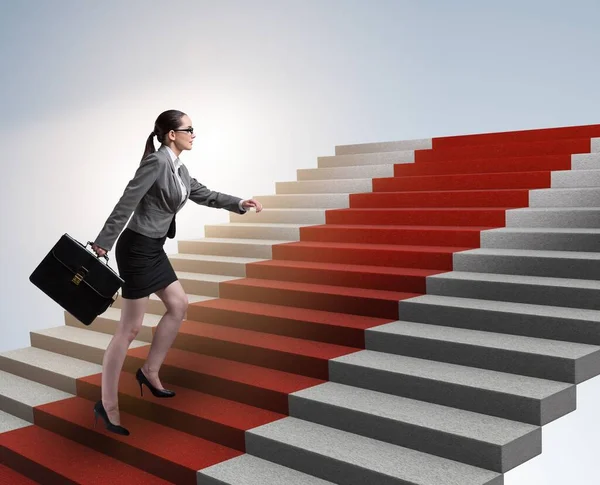 The young businesswoman climbing stairs and red carpet
