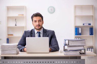 Genç bir çalışan ve ofiste çok fazla iş var.