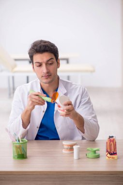 Hastanede çalışan genç bir dişçi.