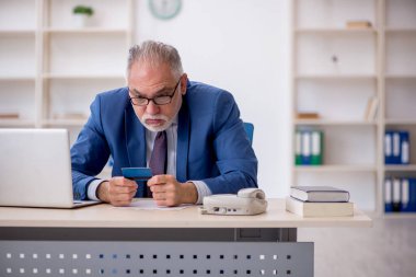 Kredi kartı tutan eski bir çalışan.