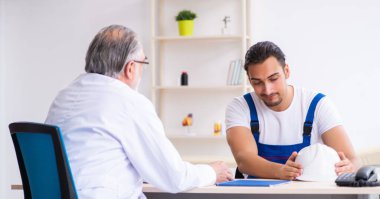 Genç erkek müteahhit yaşlı doktoru ziyaret ediyor.