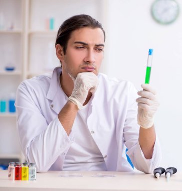 Laboratuvarda çalışan genç erkek kimyager.