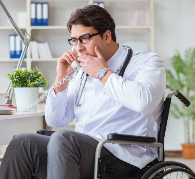 Hastanede çalışan tekerlekli sandalyedeki engelli doktor.