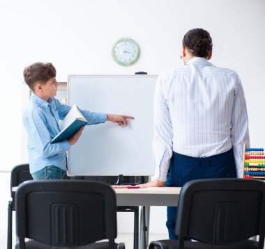 Genç baba oğlunun sınava hazırlanmasına yardım ediyor.