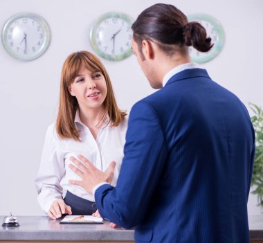 Otel resepsiyonundaki genç işadamı.